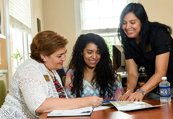 photo of a UNCG student collaborating with two university staff members